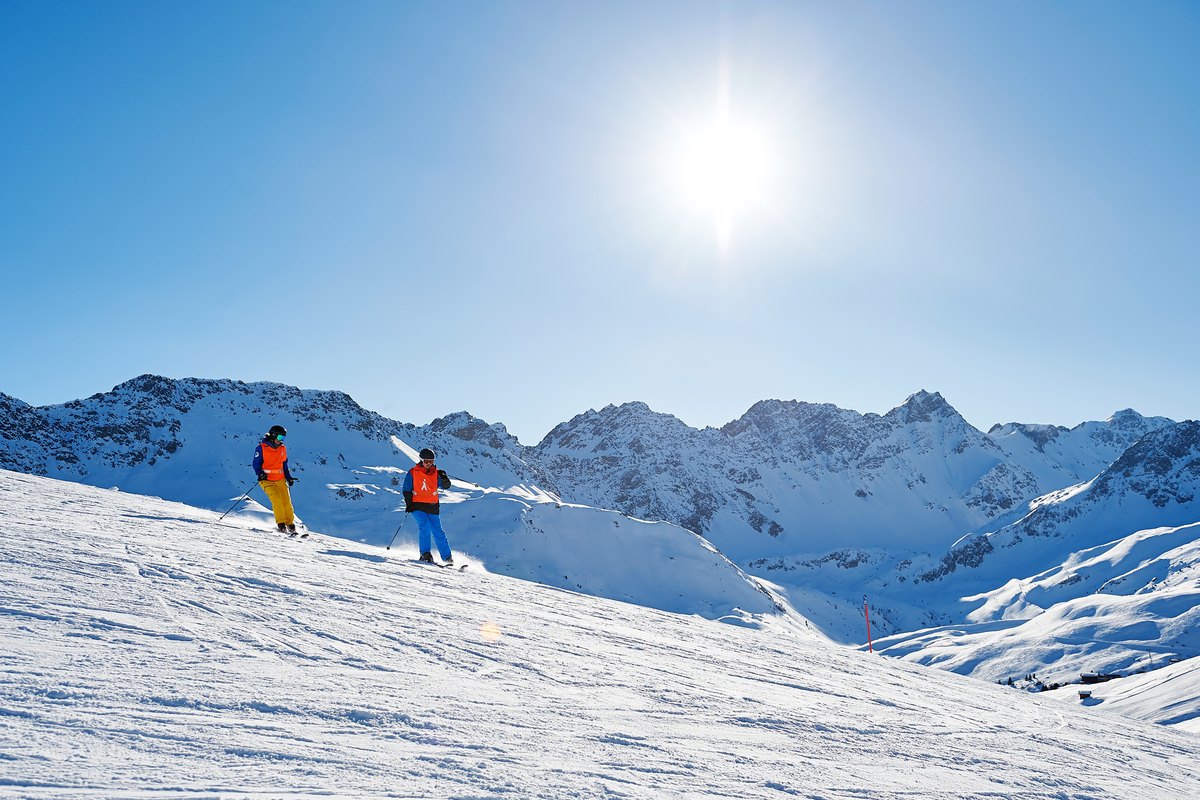 Zwei Skifahrende beim inklusiven Schneesport im Aroser Skigebiet