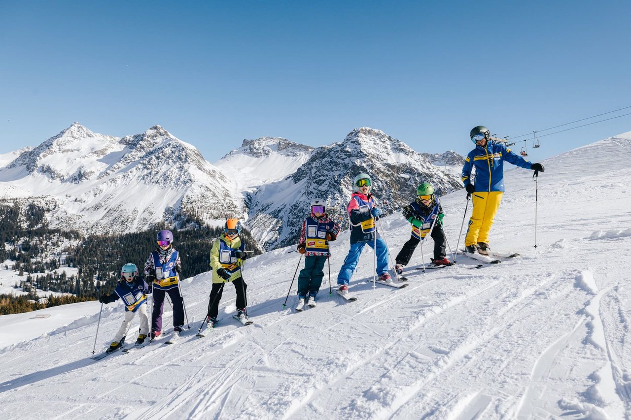 Skigruppe der Skischule Arosa mit Schneesportlehrer vor dem Bergpanorama
