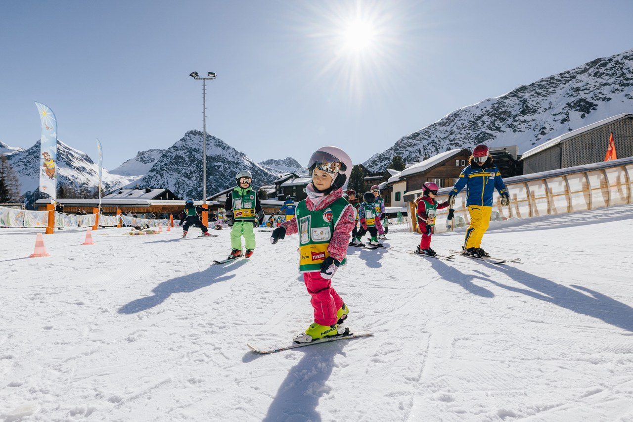 Kind auf Ski im Snowgarden der Skischule Arosa bei strahlender Wintersonne